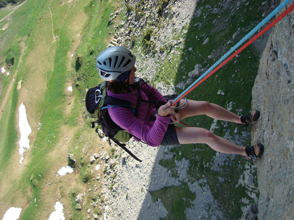 Woman mountainclimbing with gear, rope, and helmet, photo by Mike Bean