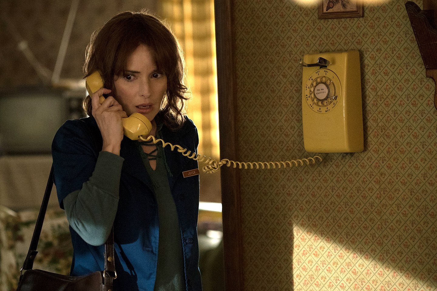 Joyce Byers (Winona Ryder) answers the telephone in Netflix's series Stranger Things