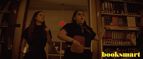 Amy (Kaitlyn Dever) and Molly (Beanie Feldstein) enter the library in the in the trailer for the movie Booksmart