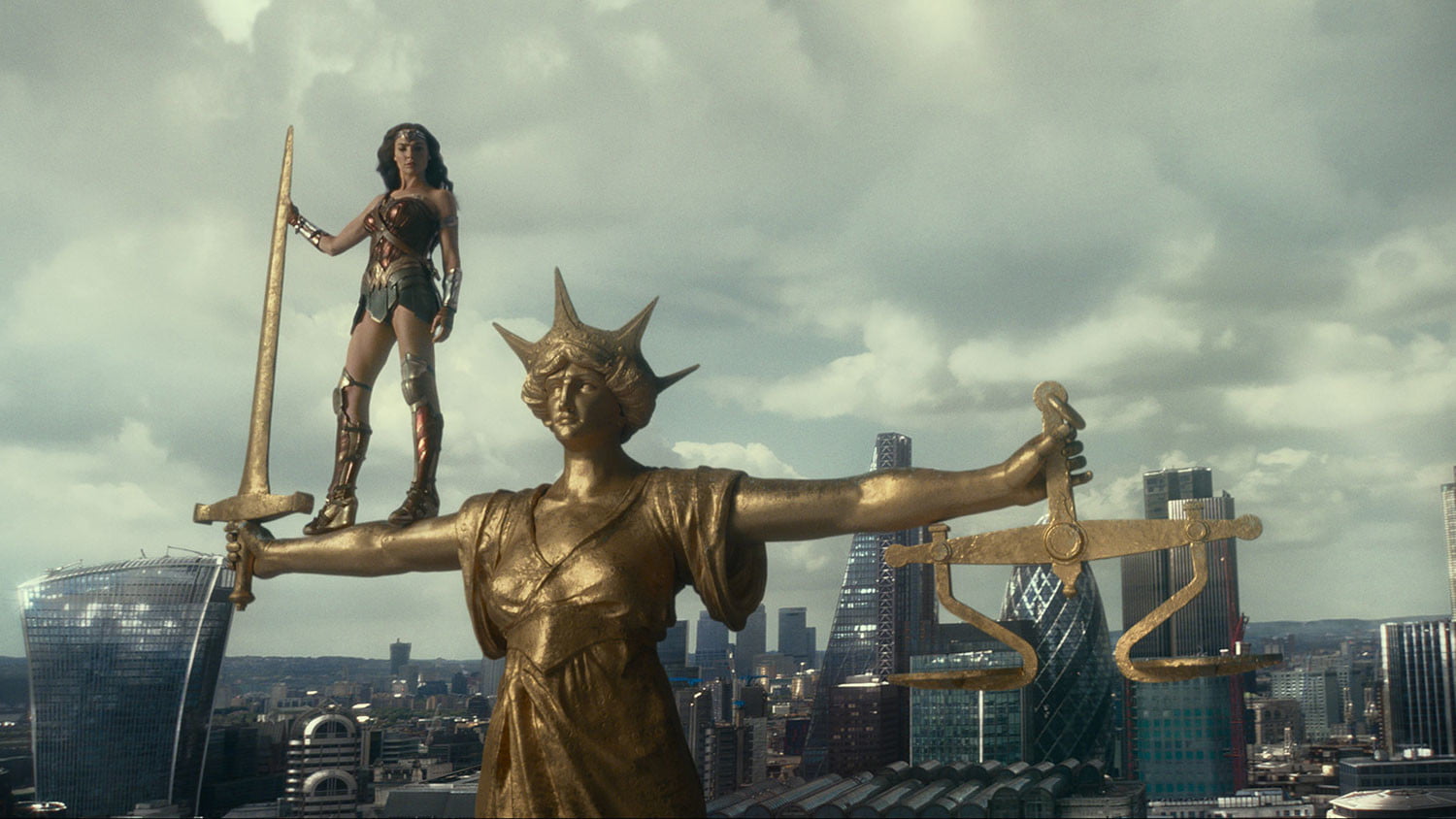 Wonder Woman (Gal Gadot) stands atop a statue of Justice in London in the Justice League movie