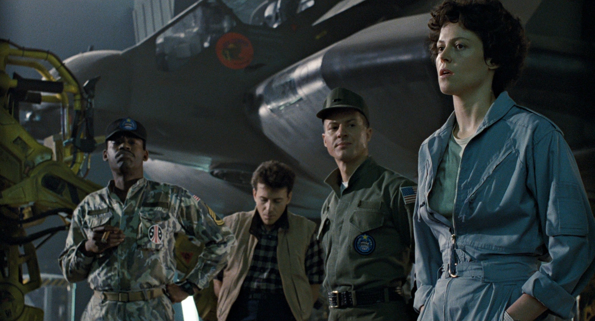 Apone, Burke, and Gorman listen as Ripley briefs the marines in Aliens